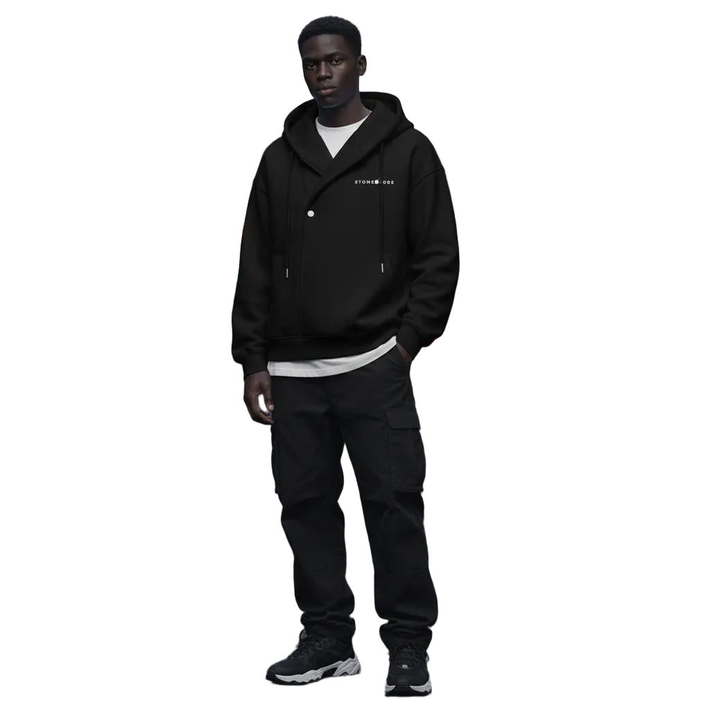 Unisex black oversized cotton blend hoodie with button placket, drawstring, and drop shoulders, worn by a model.