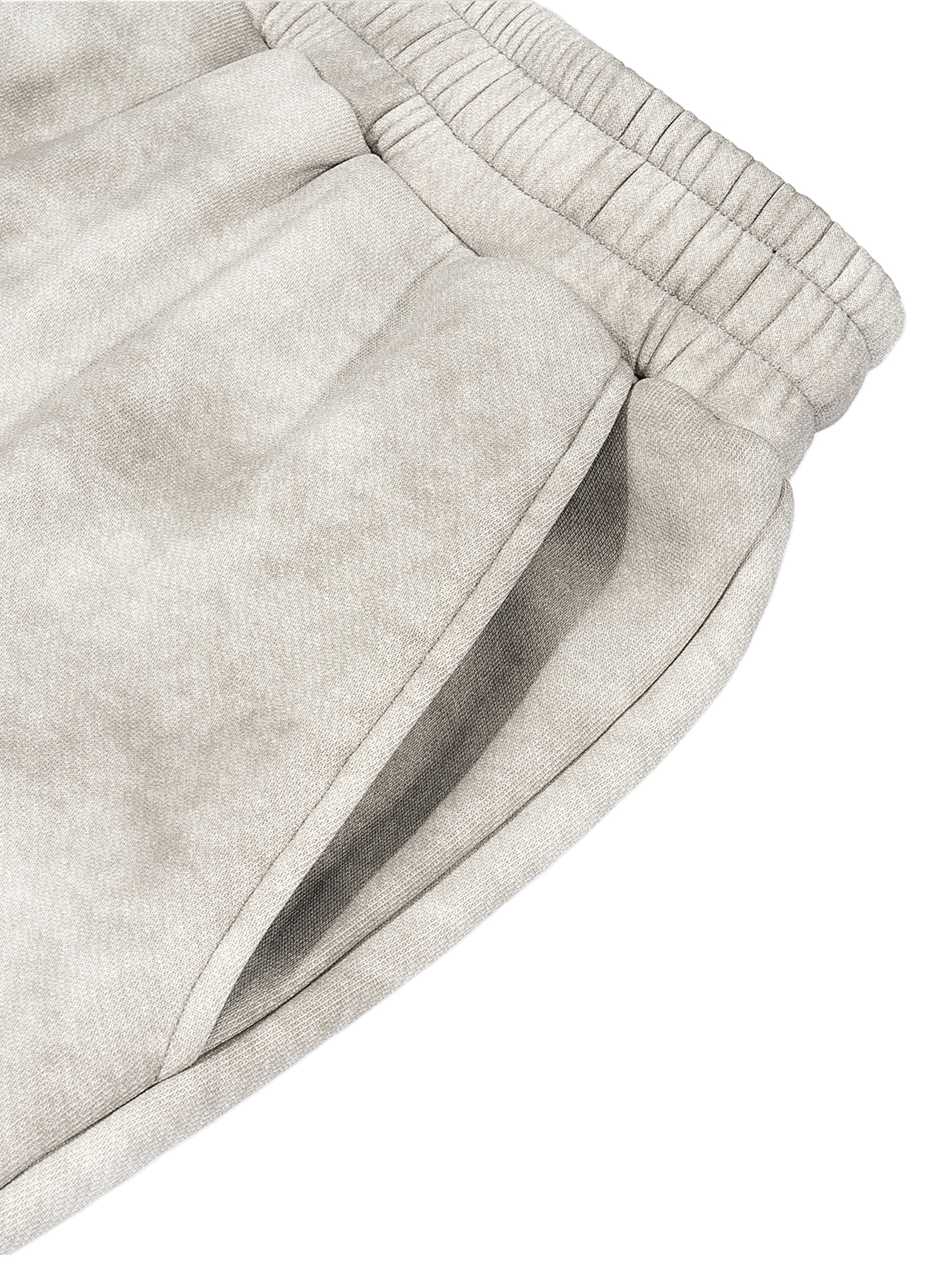 Close-up of dirty washed grey fleece sweatpants with an elastic waistband and side pocket.