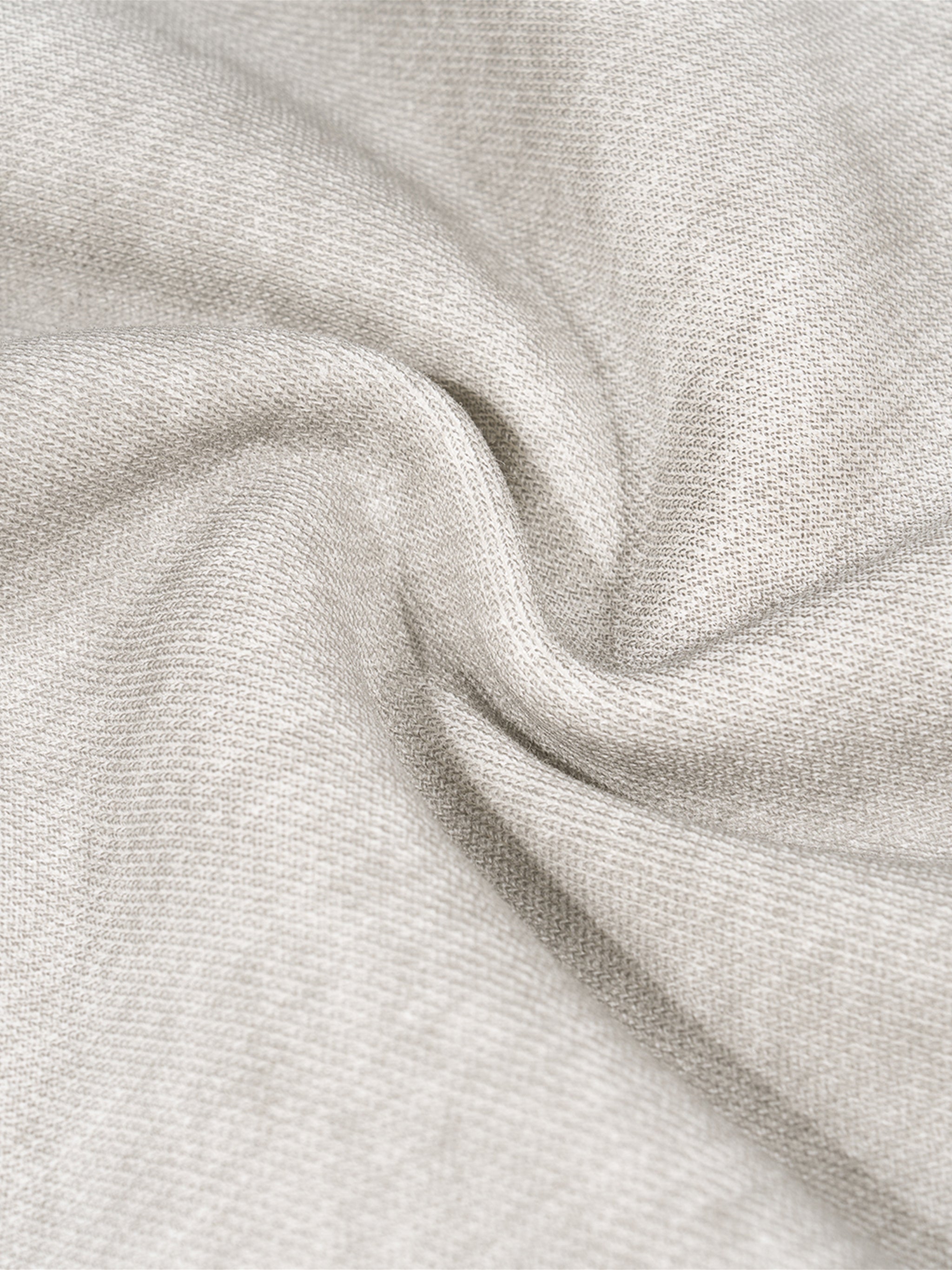 Close-up of dirty washed grey fleece sweatpant fabric, showing soft texture and subtle wrinkles.