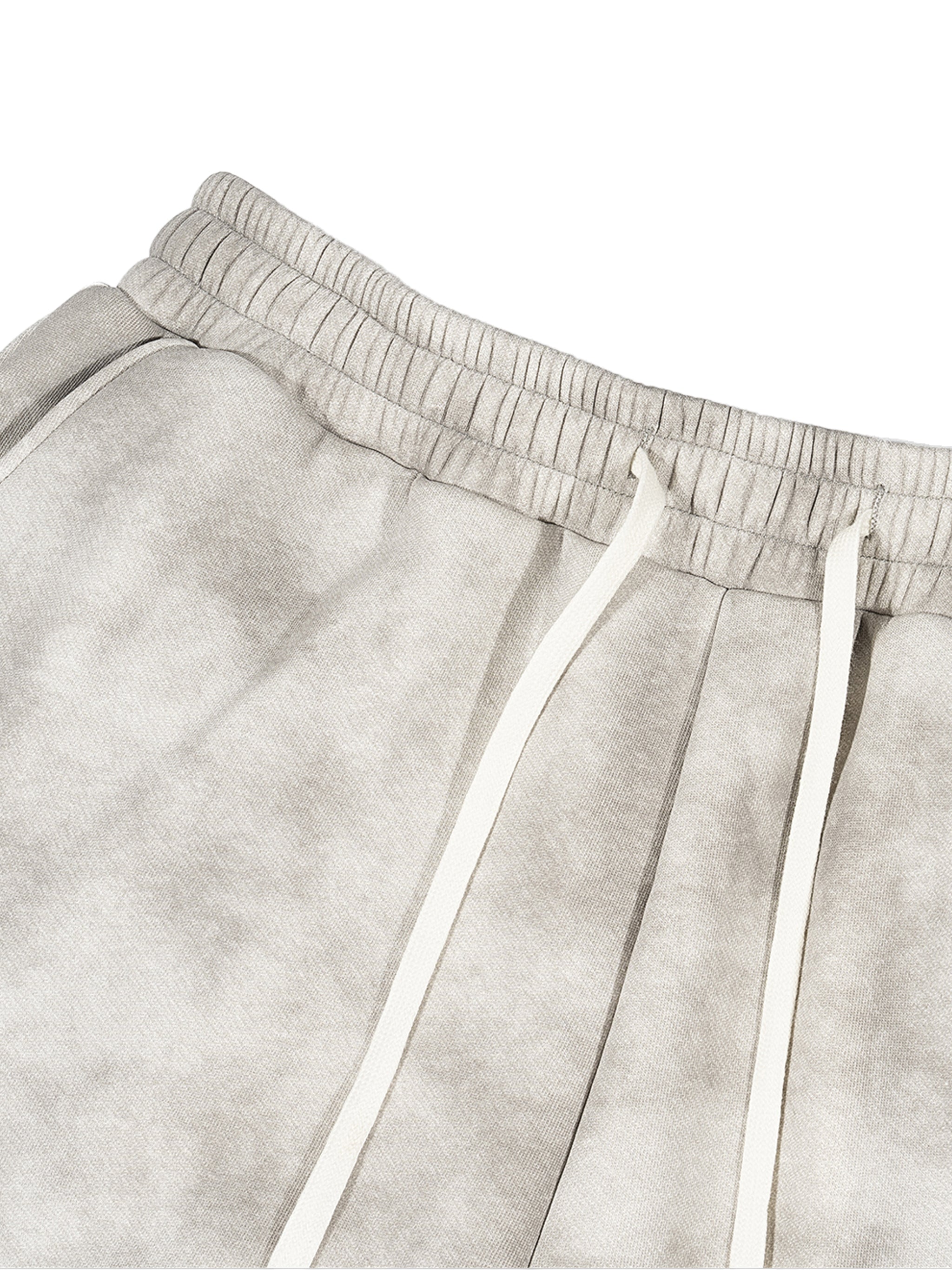 Close-up of dirty washed grey fleece sweatpants with elastic mid-waist and white drawstring.