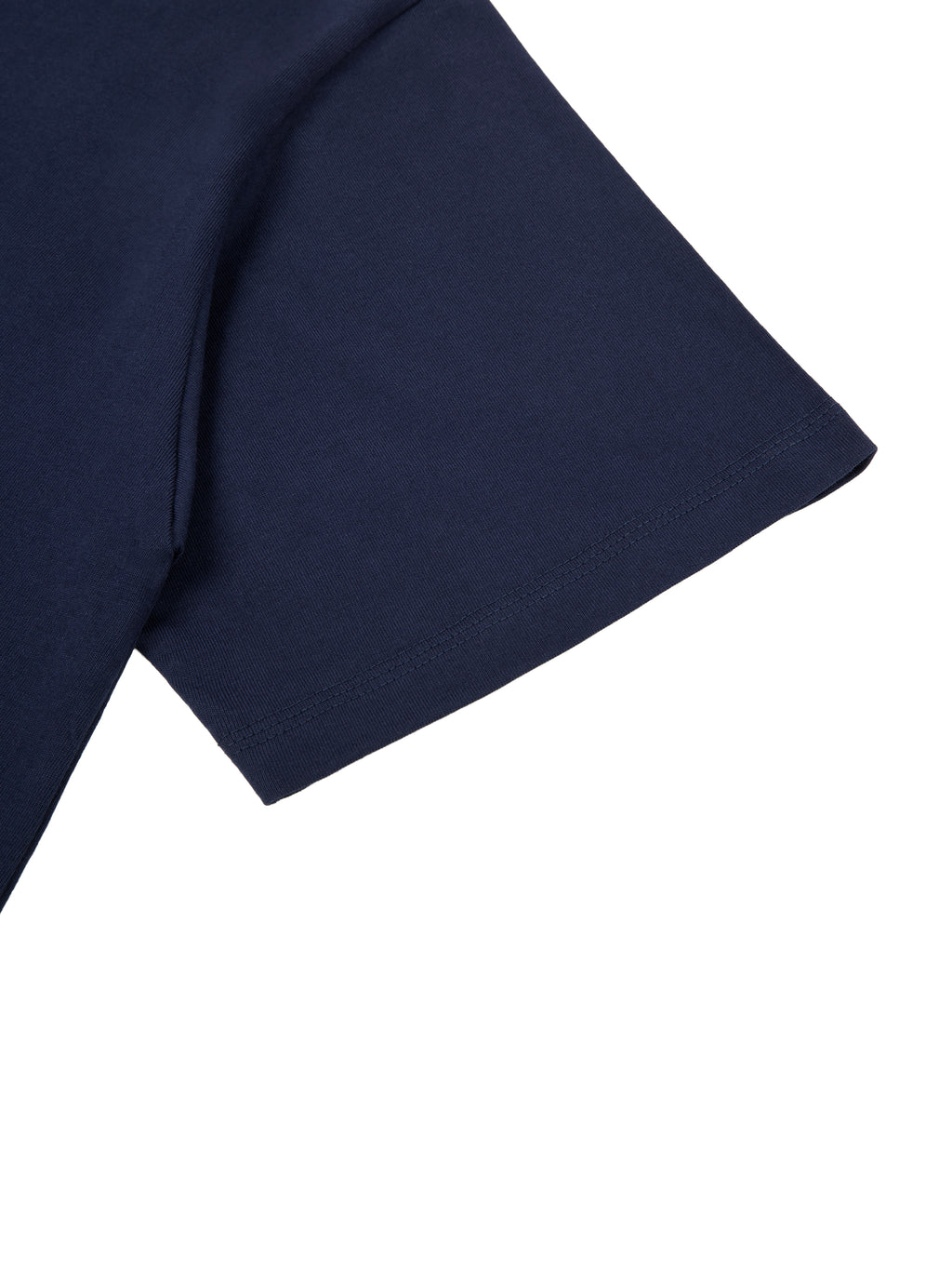 Close-up of a dark blue essential cotton t-shirt sleeve and shoulder, showing the fabric texture and stitching.