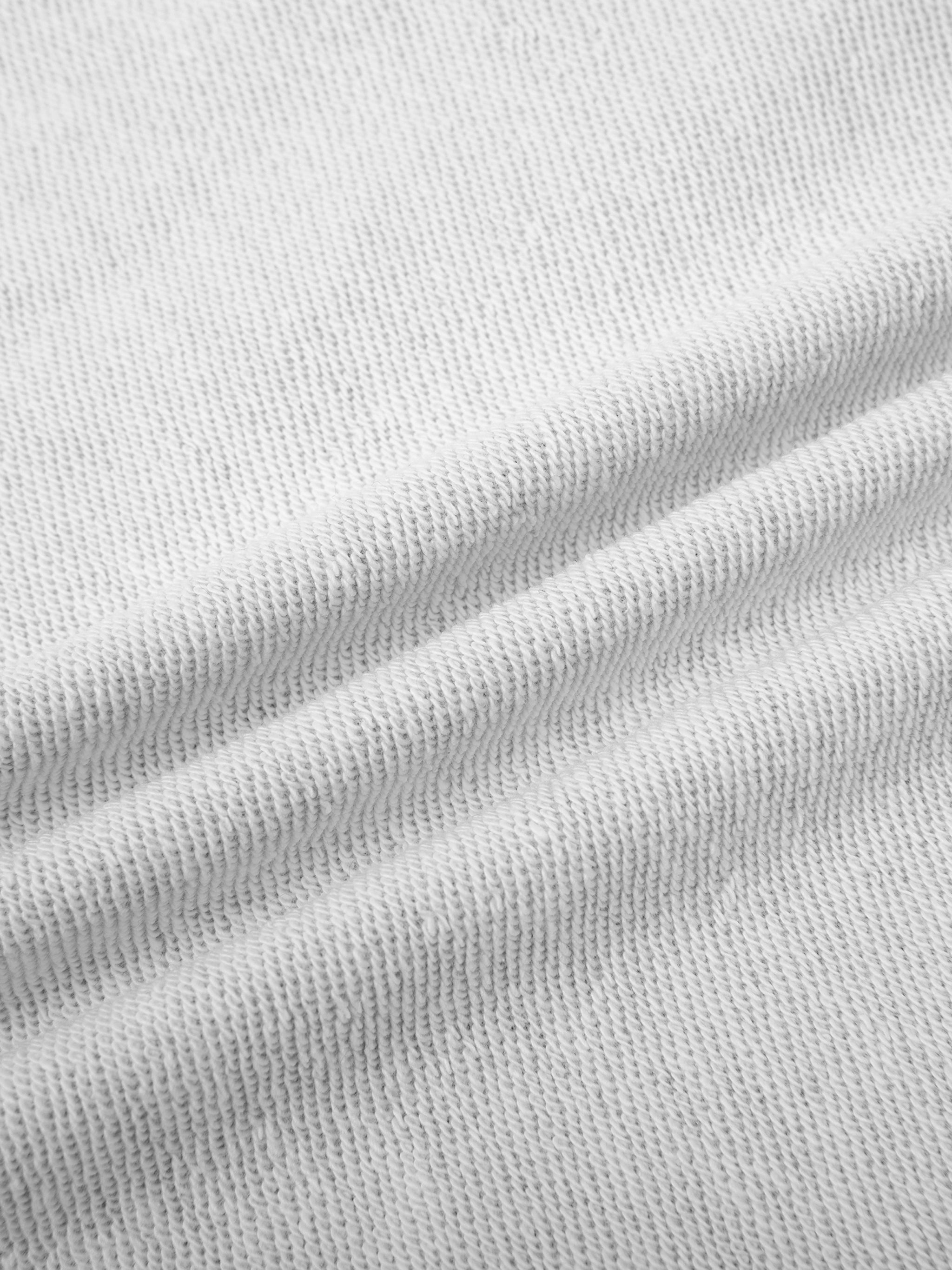 Close-up of light gray cotton blend fabric for the Essential Cropped Hoodie, showing its texture and slight folds.