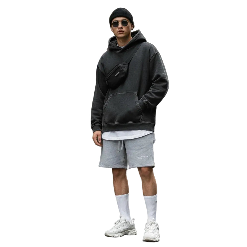 Unisex model wearing gray heavyweight fleece shorts, black oversized hoodie, beanie, and white sneakers.