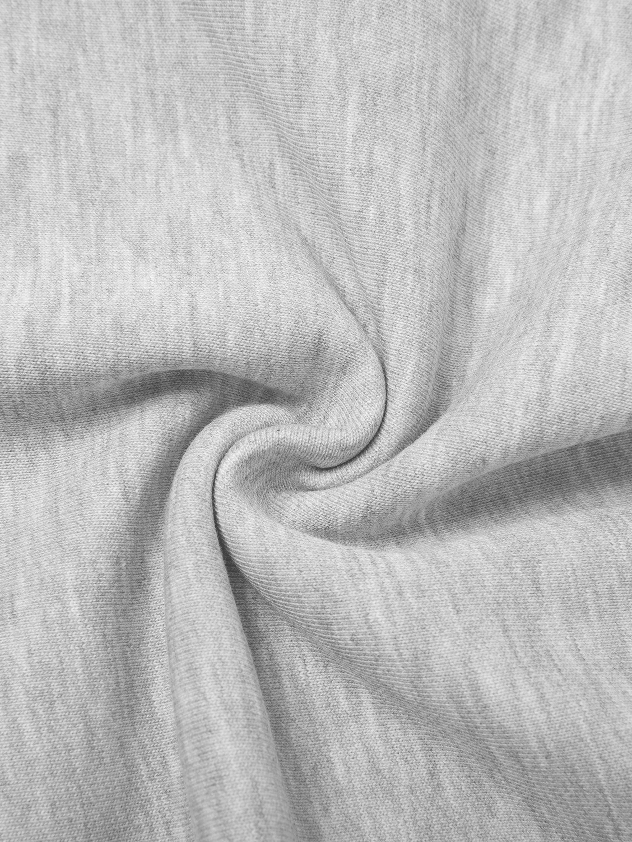 Close-up of light gray cotton blend fabric, showing soft texture and gentle folds.