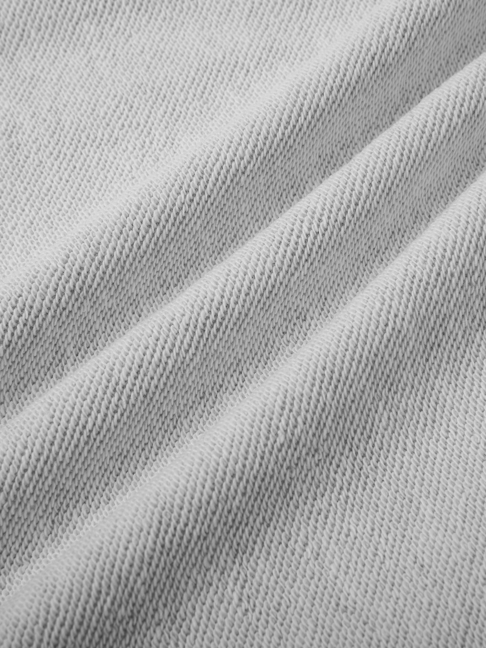 Close-up of light gray cotton blend fabric for Essential Straight-Leg Sweatpants, showing soft texture and folds.