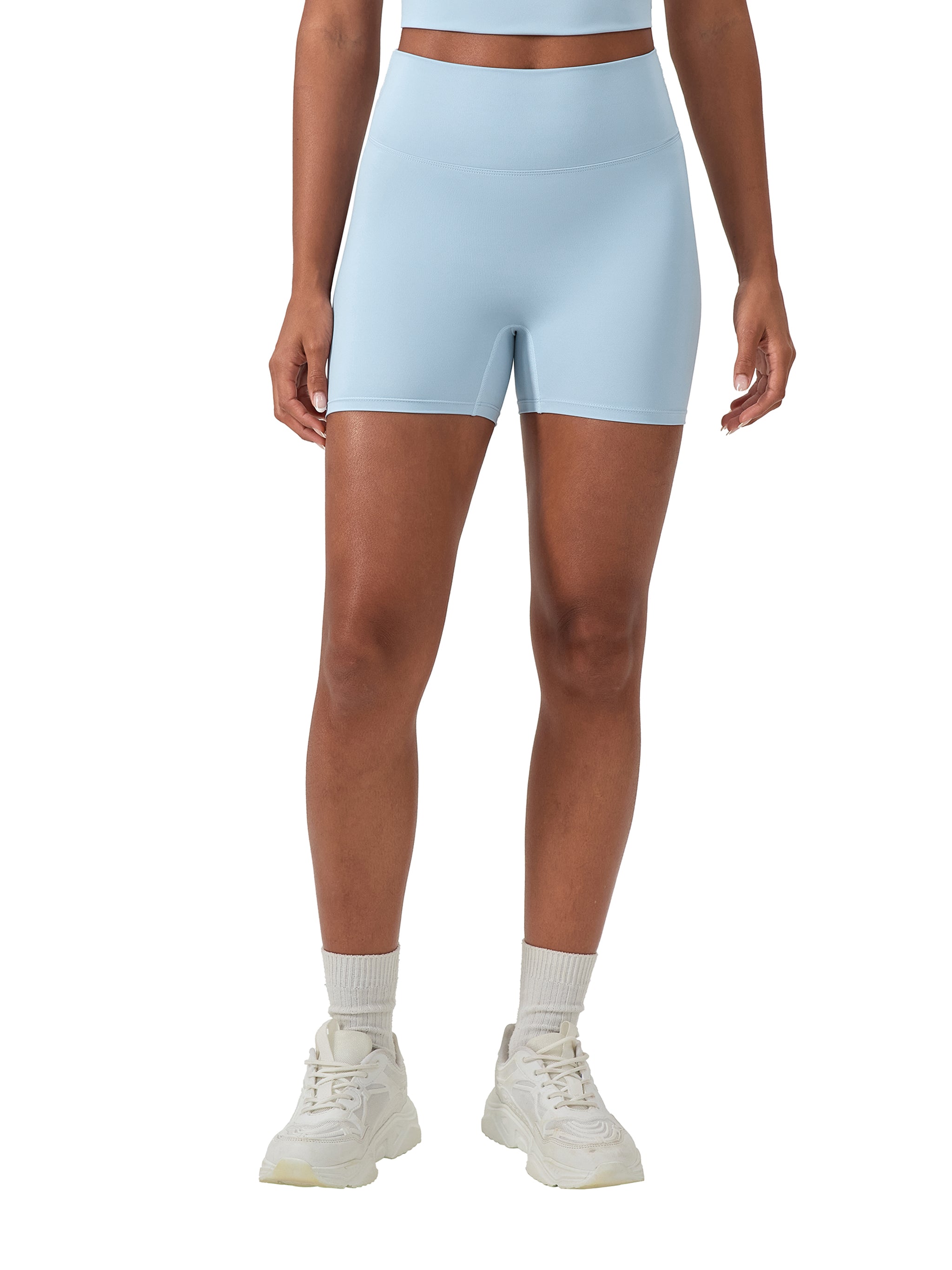Light blue high-waisted blend biker shorts on a model, paired with white socks and sneakers.