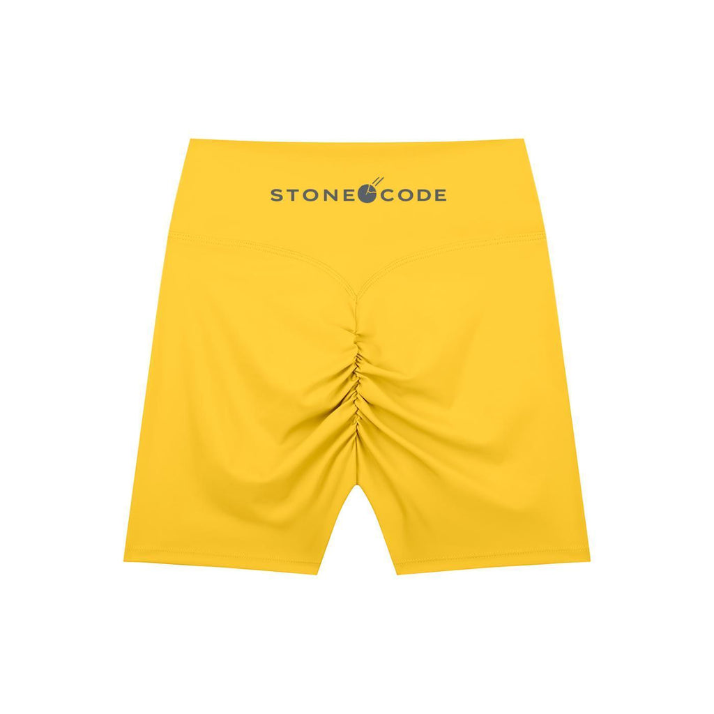 Yellow high-waisted biker shorts with a ruched back seam and "STONE CODE" logo on the waistband.
