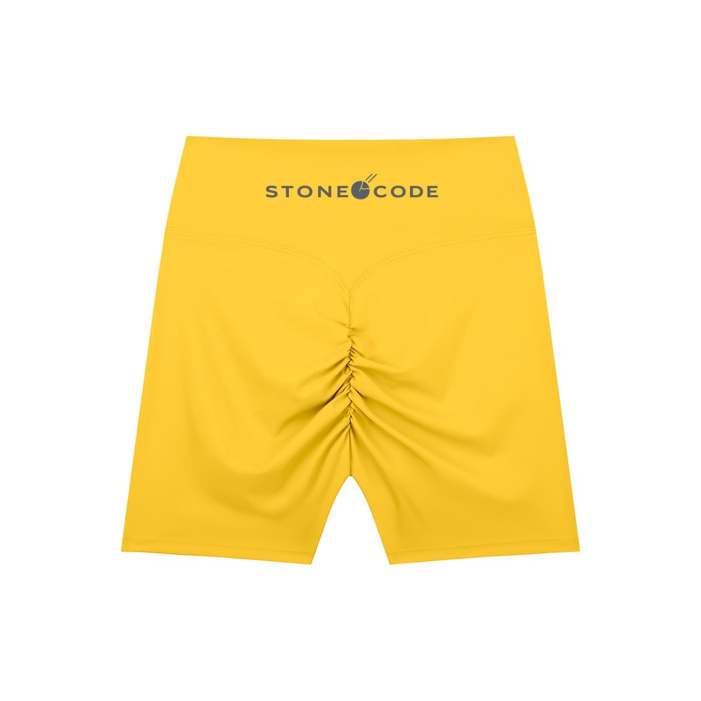 Yellow high-waisted biker shorts with a ruched back seam and "STONE CODE" logo on the waistband.
