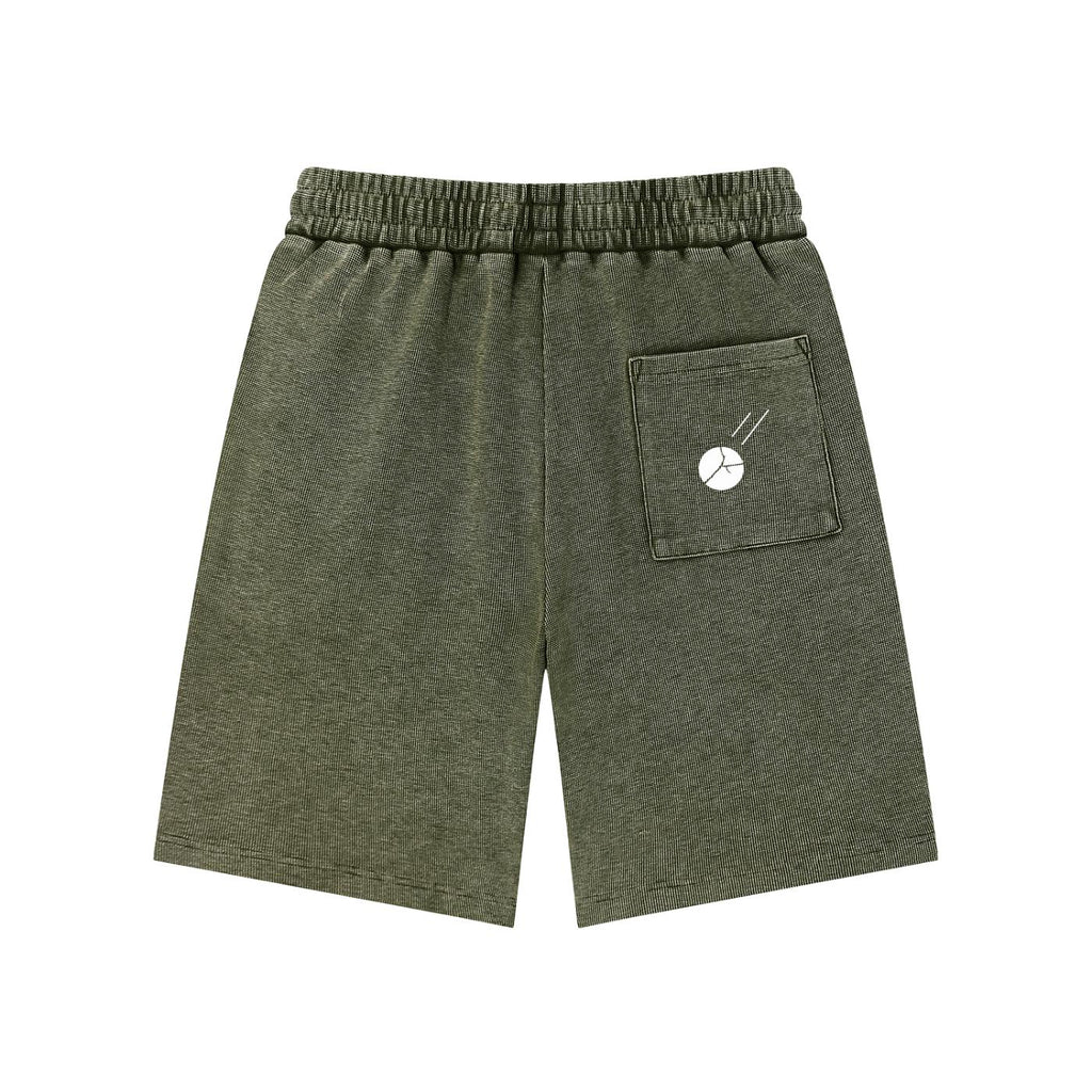 Mineral wash olive green waffle knit shorts with an elastic drawstring waist and a white graphic on the back pocket.