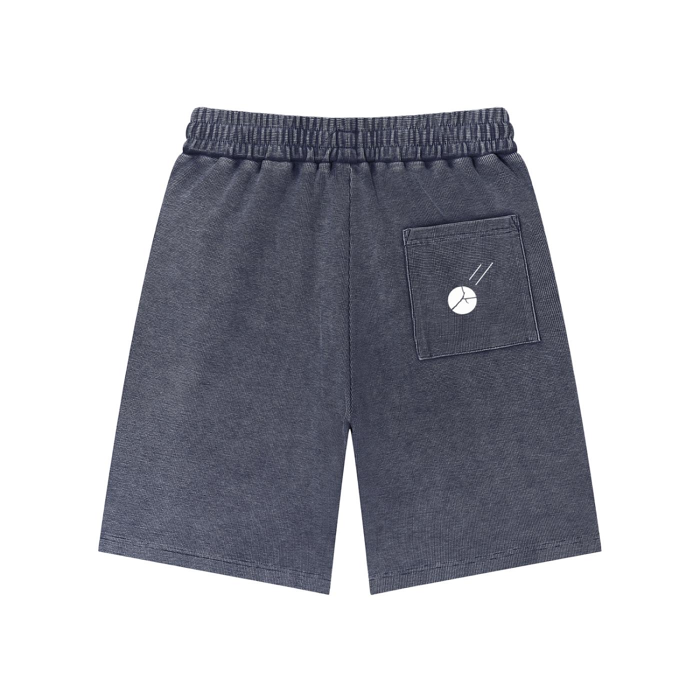 Mineral wash waffle knit shorts in dark gray with an elastic drawstring waist and a back pocket featuring a white graphic.