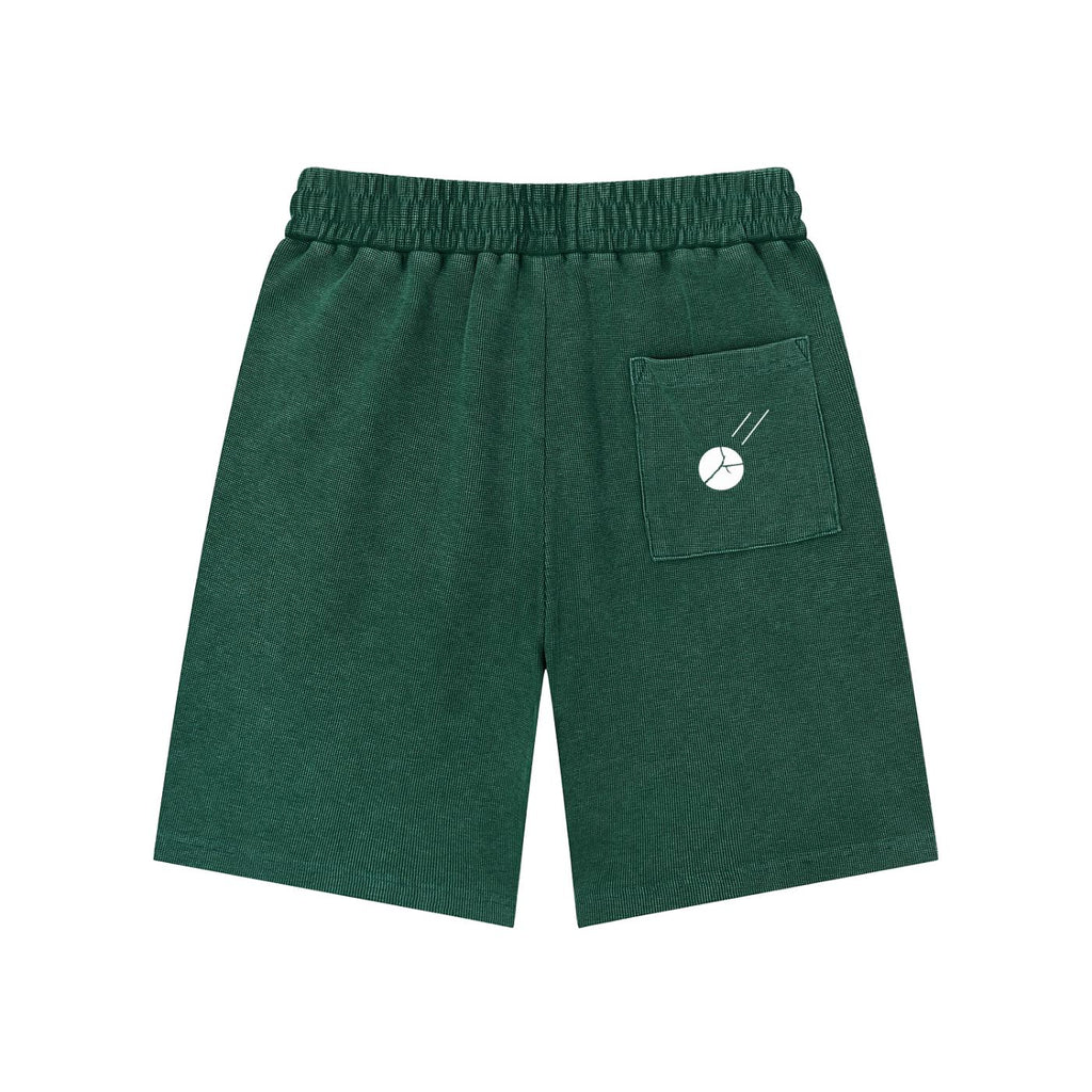Mineral wash waffle knit shorts in dark green with an elastic waist and a back pocket featuring a white graphic.