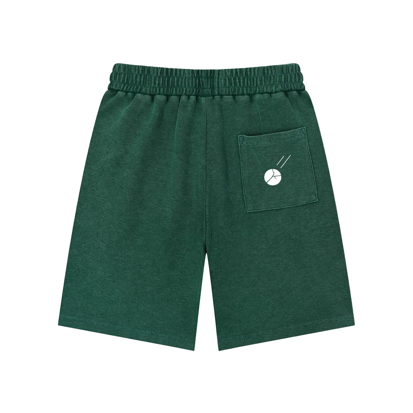 Mineral wash waffle knit shorts in dark green with an elastic waist and a back pocket featuring a white graphic.