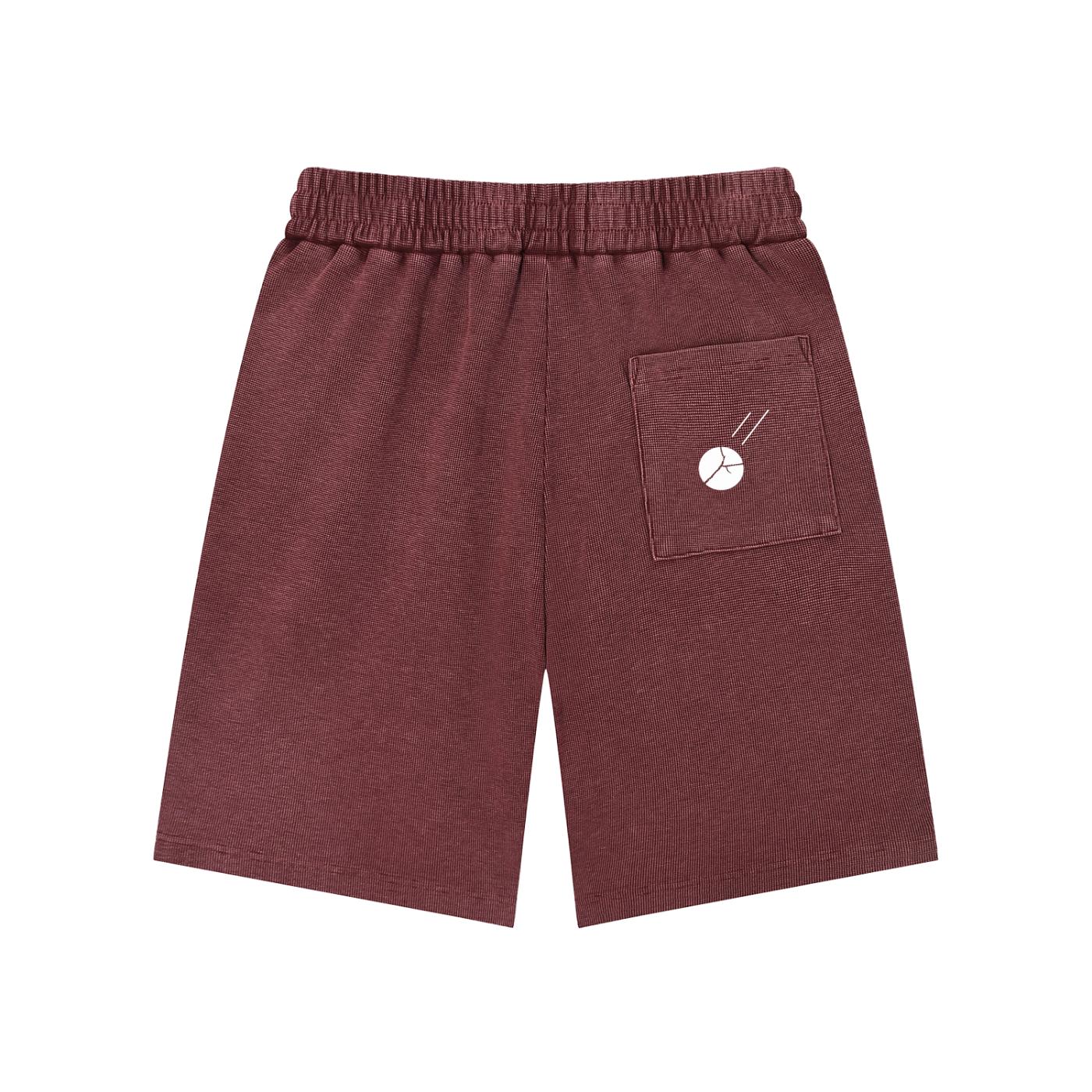 Mineral wash waffle knit shorts in maroon with an elastic drawstring waist and a white Sputnik graphic on the back pocket.