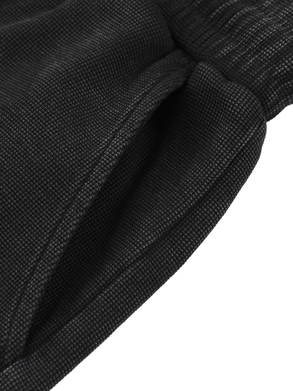 Close-up of dark gray mineral wash waffle knit shorts with a side pocket and drawstring waist.