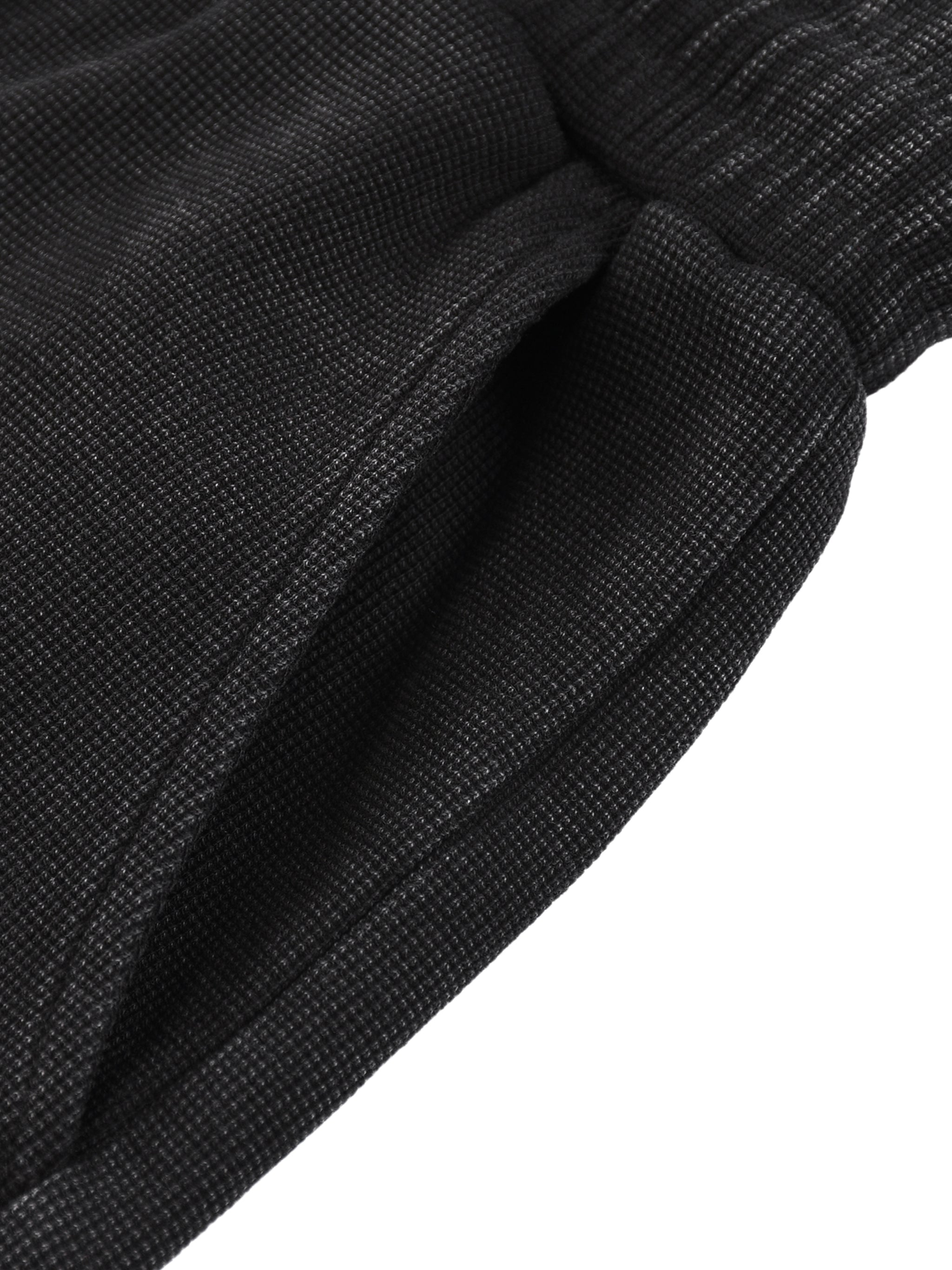 Close-up of dark gray mineral wash waffle knit shorts with a side pocket and drawstring waist.