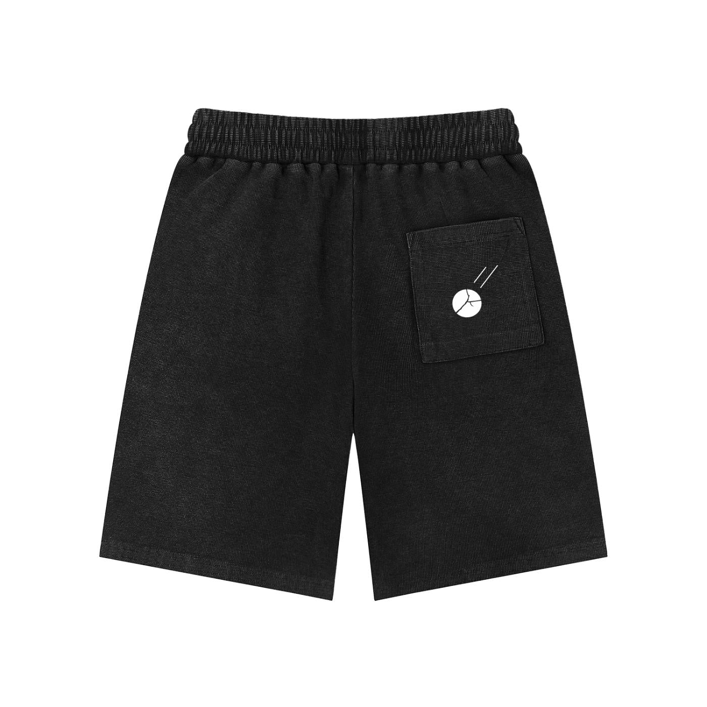 Mineral wash black waffle knit shorts with elastic waist and white graphic pocket.
