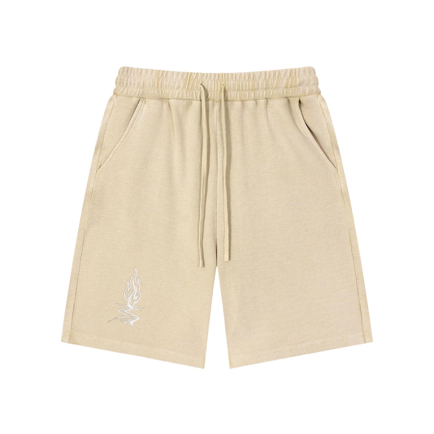 Beige mineral wash waffle knit shorts with drawstring waist, pockets, and a subtle white graphic.