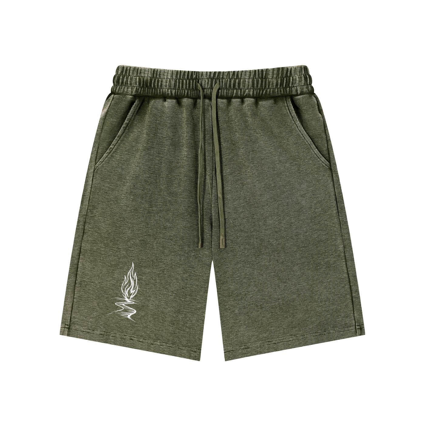 Mineral wash olive green waffle knit shorts with drawstring waist, pockets, and a white flame graphic.