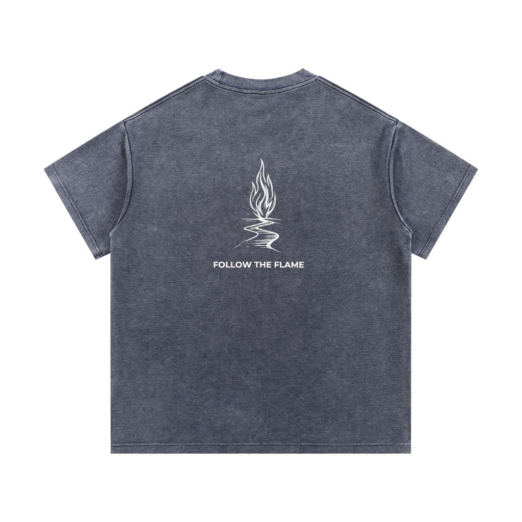 Mineral wash waffle knit t-shirt in dark gray with a white "Follow the Flame" graphic on the back.