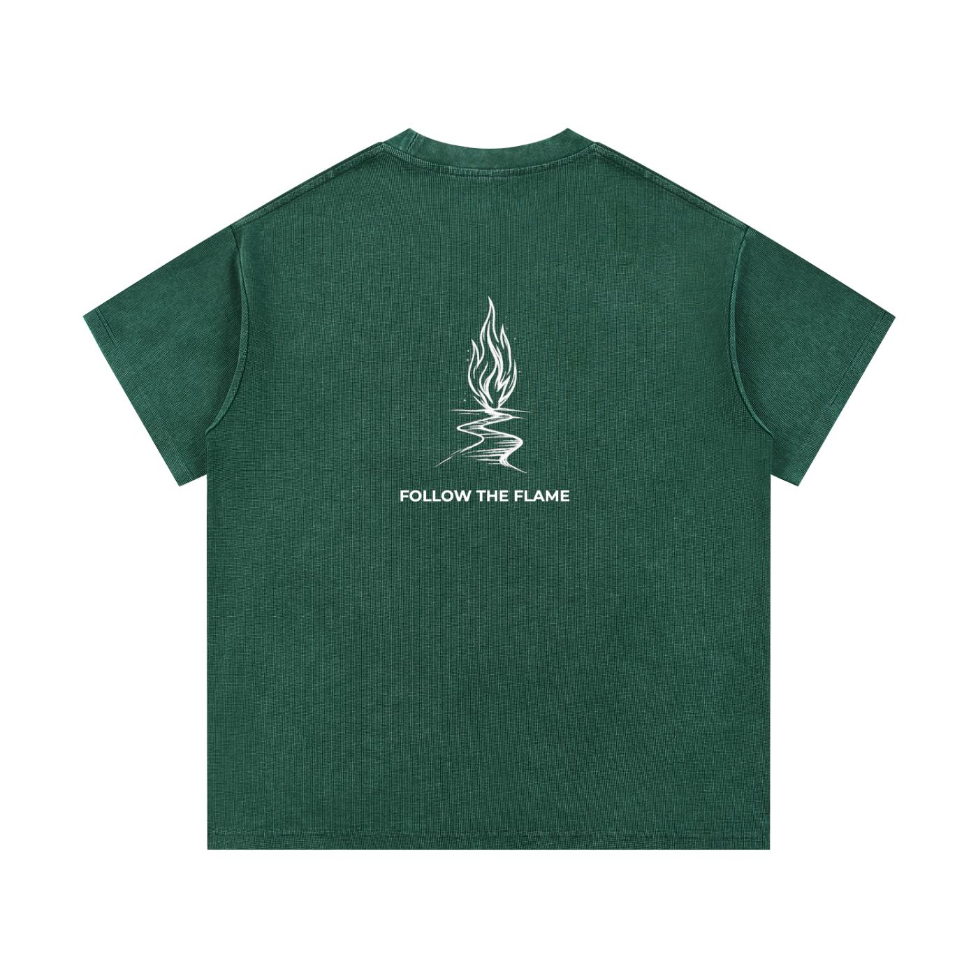 Mineral wash waffle knit t-shirt in dark green with a white "Follow the Flame" graphic on the back.
