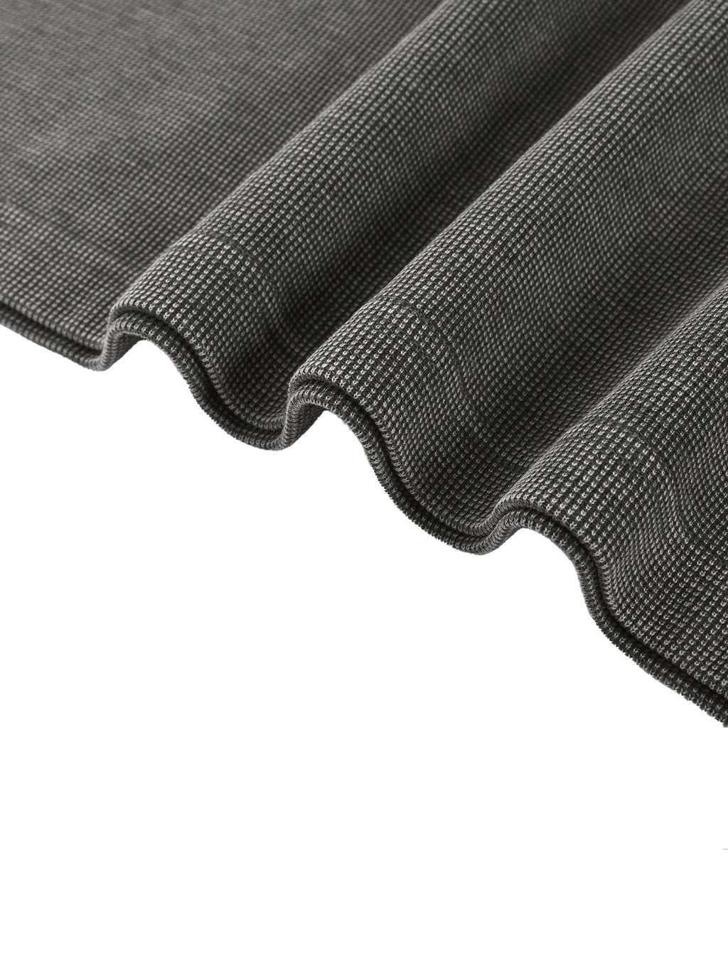 Close-up of a dark grey mineral wash waffle knit t-shirt fabric, showing texture and soft folds.