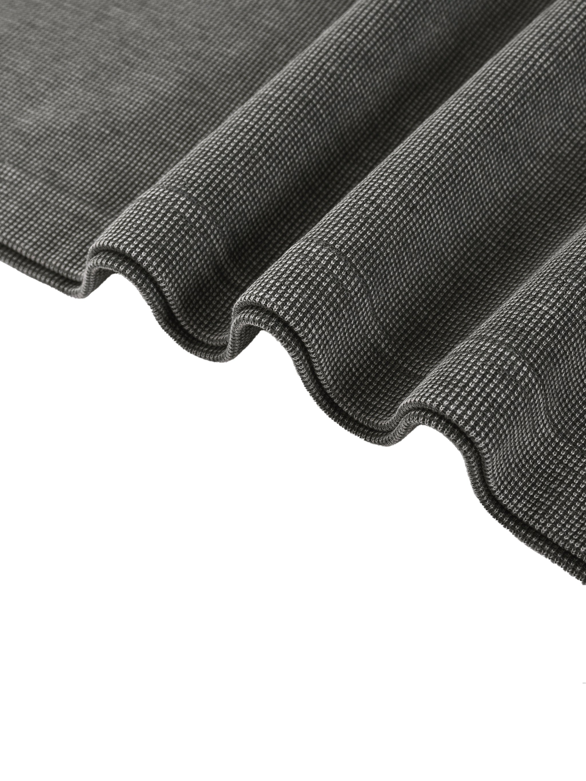 Close-up of a dark grey mineral wash waffle knit t-shirt fabric, showing texture and soft folds.