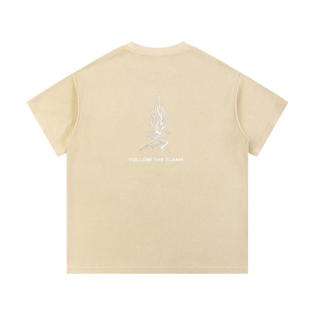 Back of a loose-fit mineral wash waffle knit t-shirt in light yellow with a "Follow The Flame" graphic.