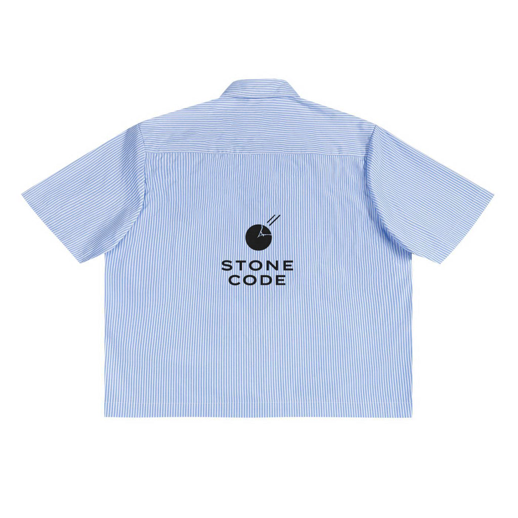 Back of an oversized blue and white vertical stripe boxy shirt with a black "STONE CODE" logo.
