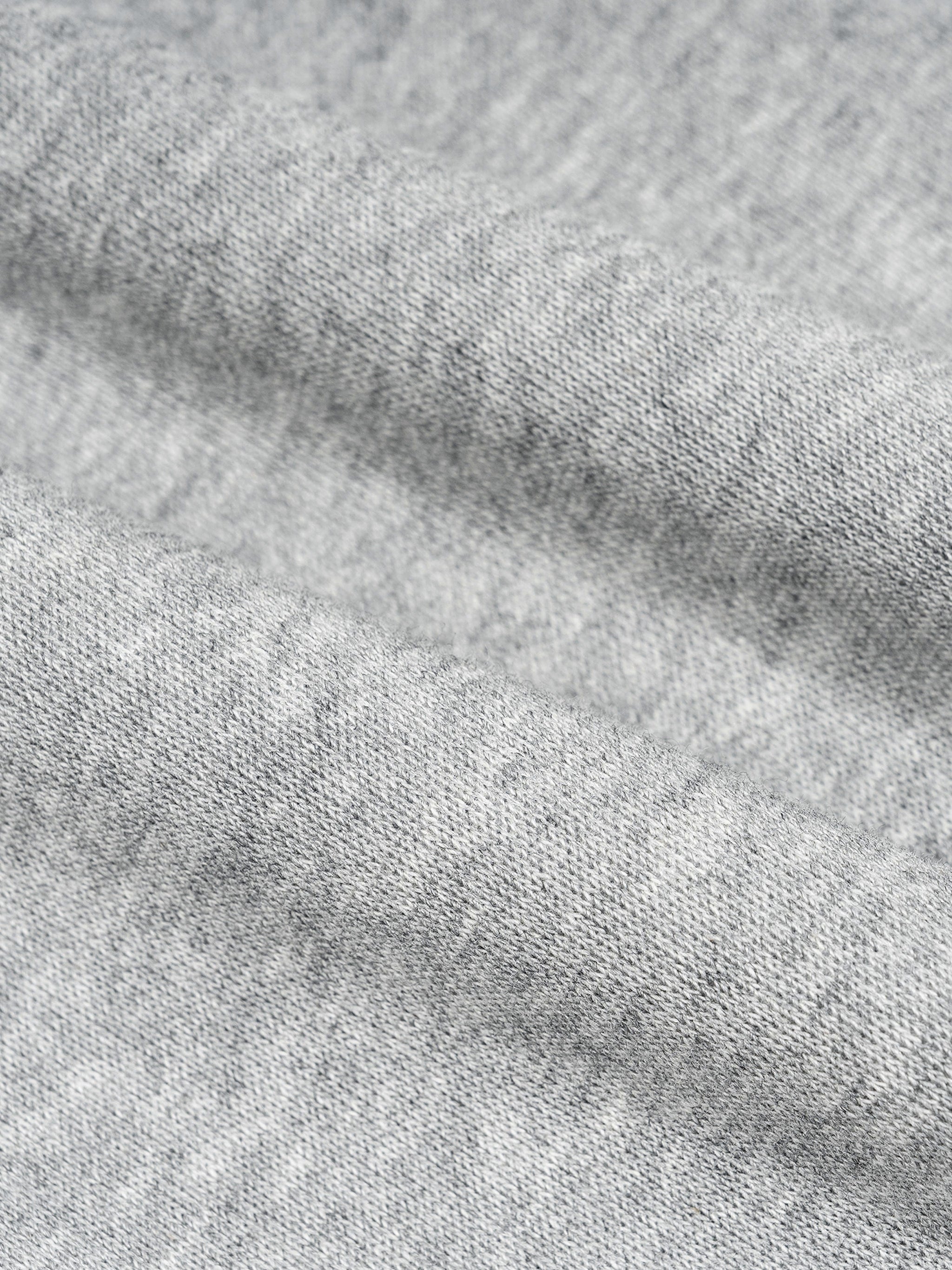 Close-up of thick, heather grey cotton blend fabric with subtle folds, suitable for barrel sweatpants.