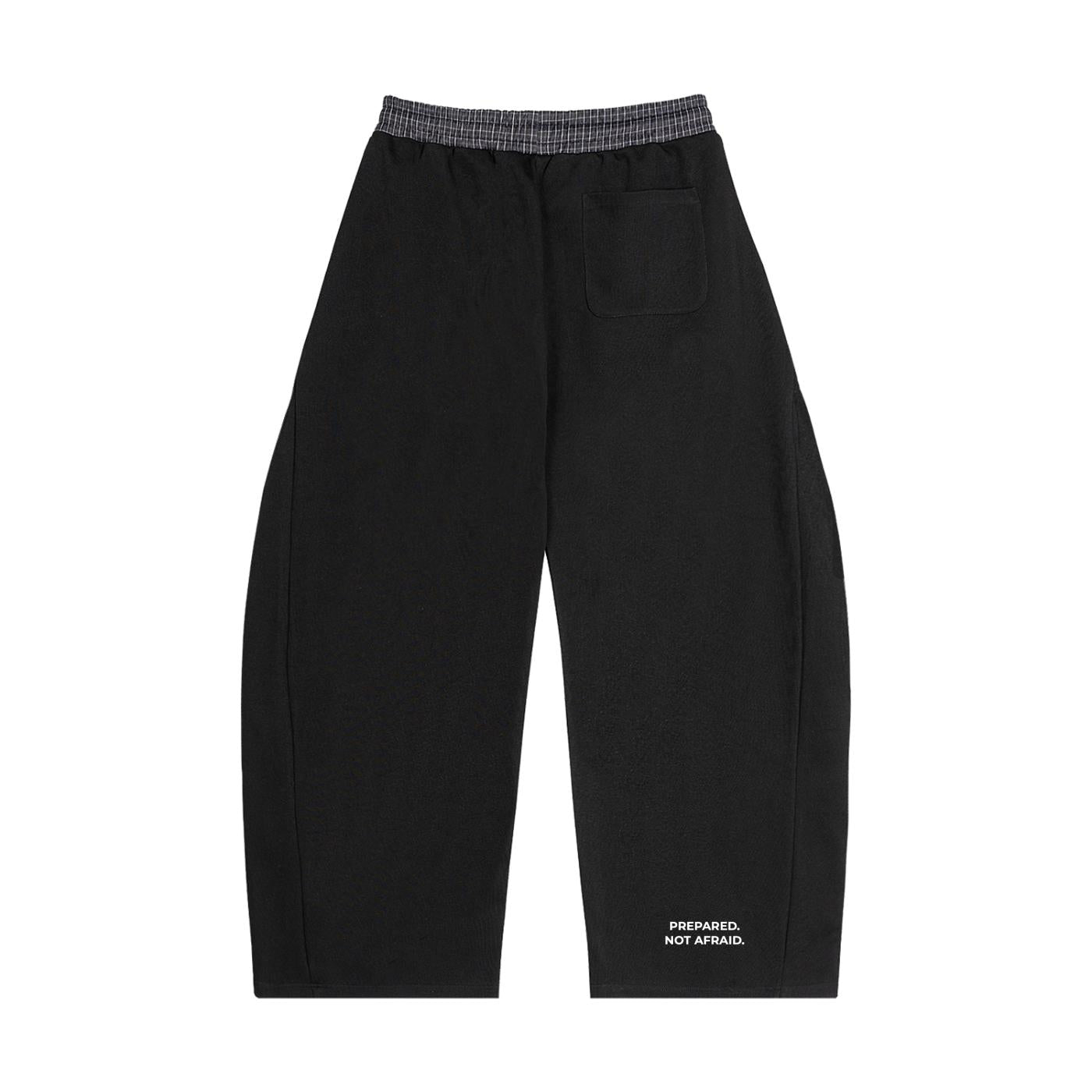 Black barrel sweatpants with a plaid waistband, back patch pocket, and "PREPARED. NOT AFRAID." text on the lower leg.