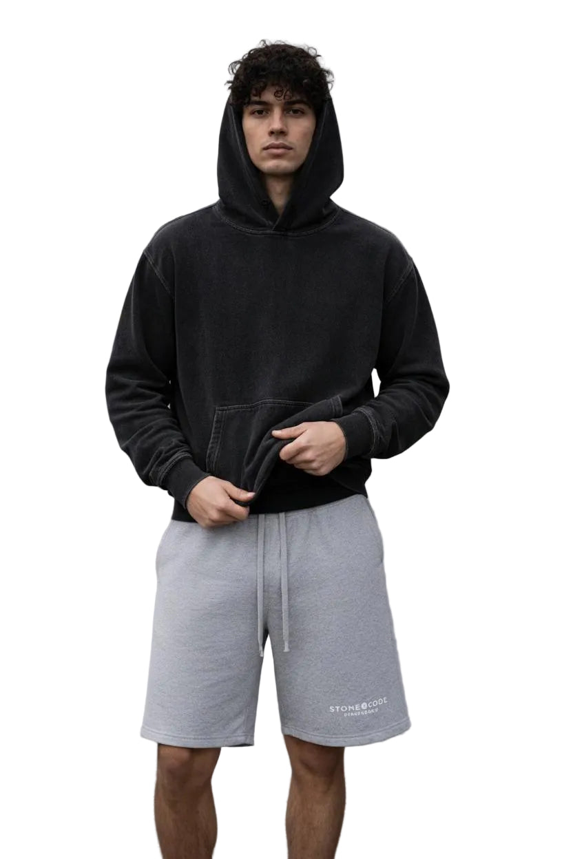 Unisex snow washed loose cotton hoodie in dark gray, worn by a model outdoors.