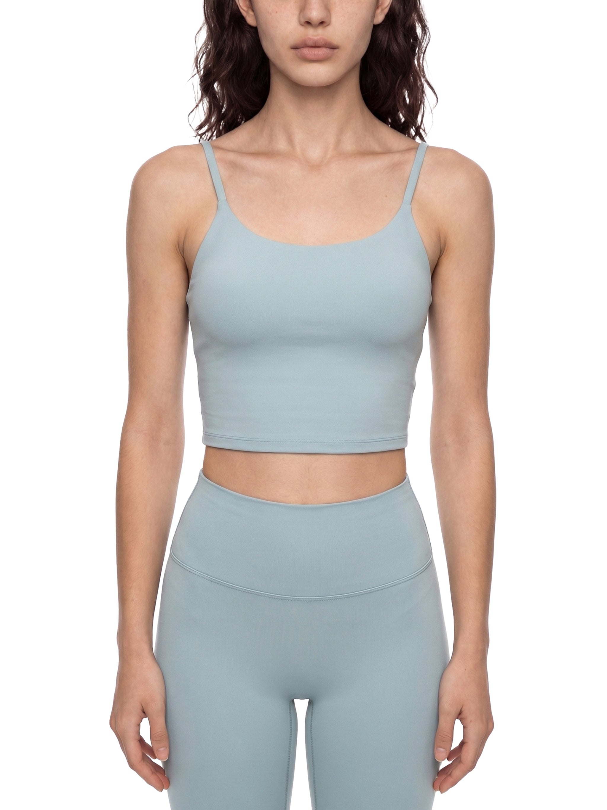 Light blue spaghetti strap yoga sports bra and matching high-waisted leggings on a model.