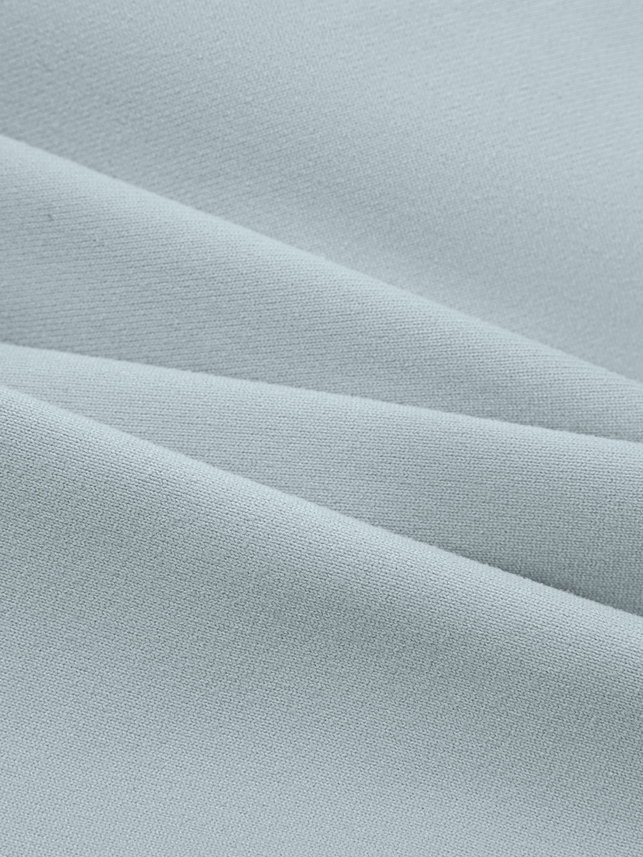 Close-up of light blue, soft, ribbed fabric, likely for a spaghetti strap yoga sports bra.