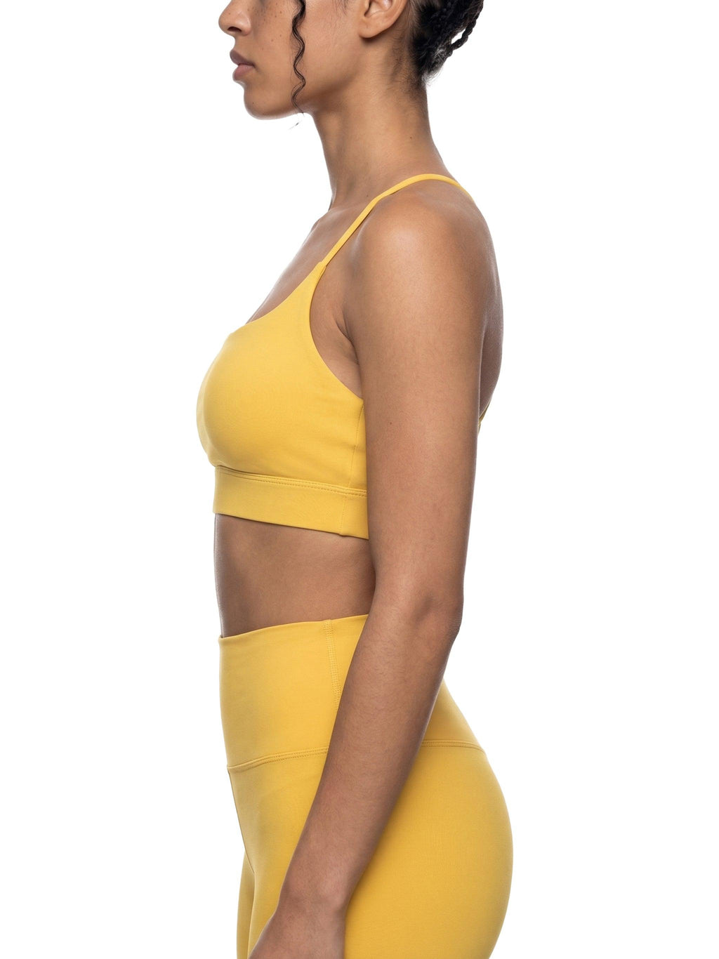 Yellow strappy criss-cross yoga sports bra and matching high-waisted leggings on a model.