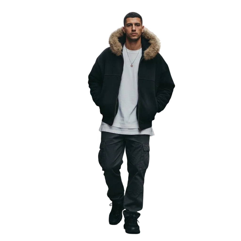 Unisex black boxy detachable fur hoodie, cotton blend, worn by a man on a city street.
