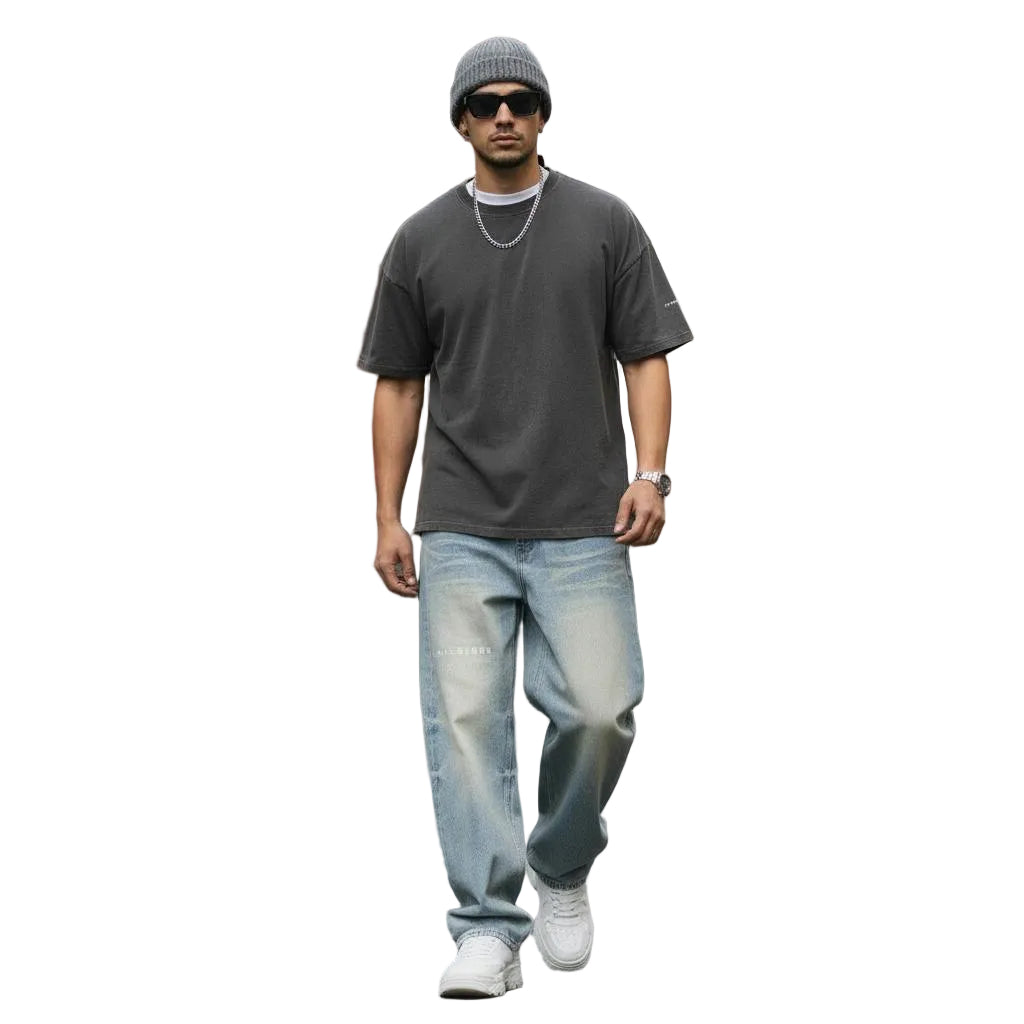 Unisex Sun Fade Raw Hem Denim Jeans with wide leg and mid waist, paired with a dark tee and beanie.