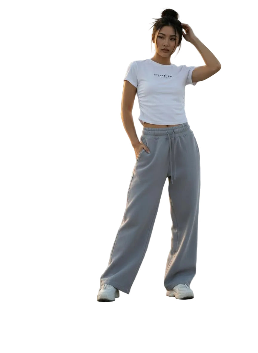 Woman in a white vintage washed bodycon cotton t-shirt and grey sweatpants on a rooftop.