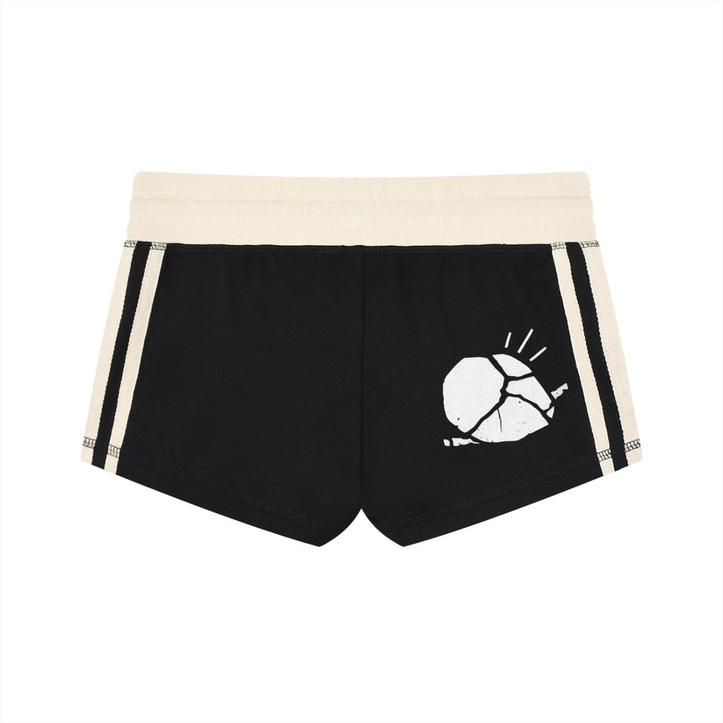 Women's black track shorts with cream contrast stripes, elastic mid-waistband, and white cracked shell graphic.
